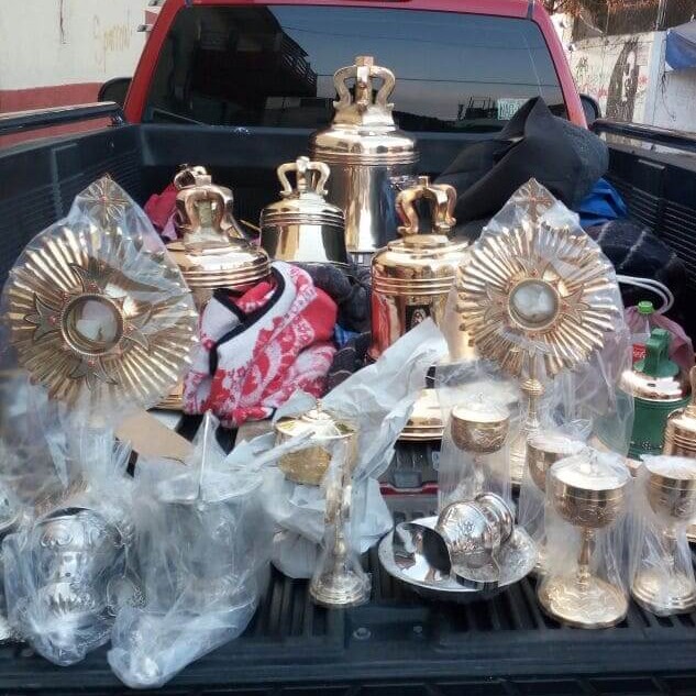 Artículos religiosos y campanas de bronce en la parte trasera de una camioneta.