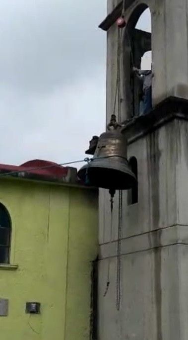 Proceso de instalación de una campana en una torre de iglesia.