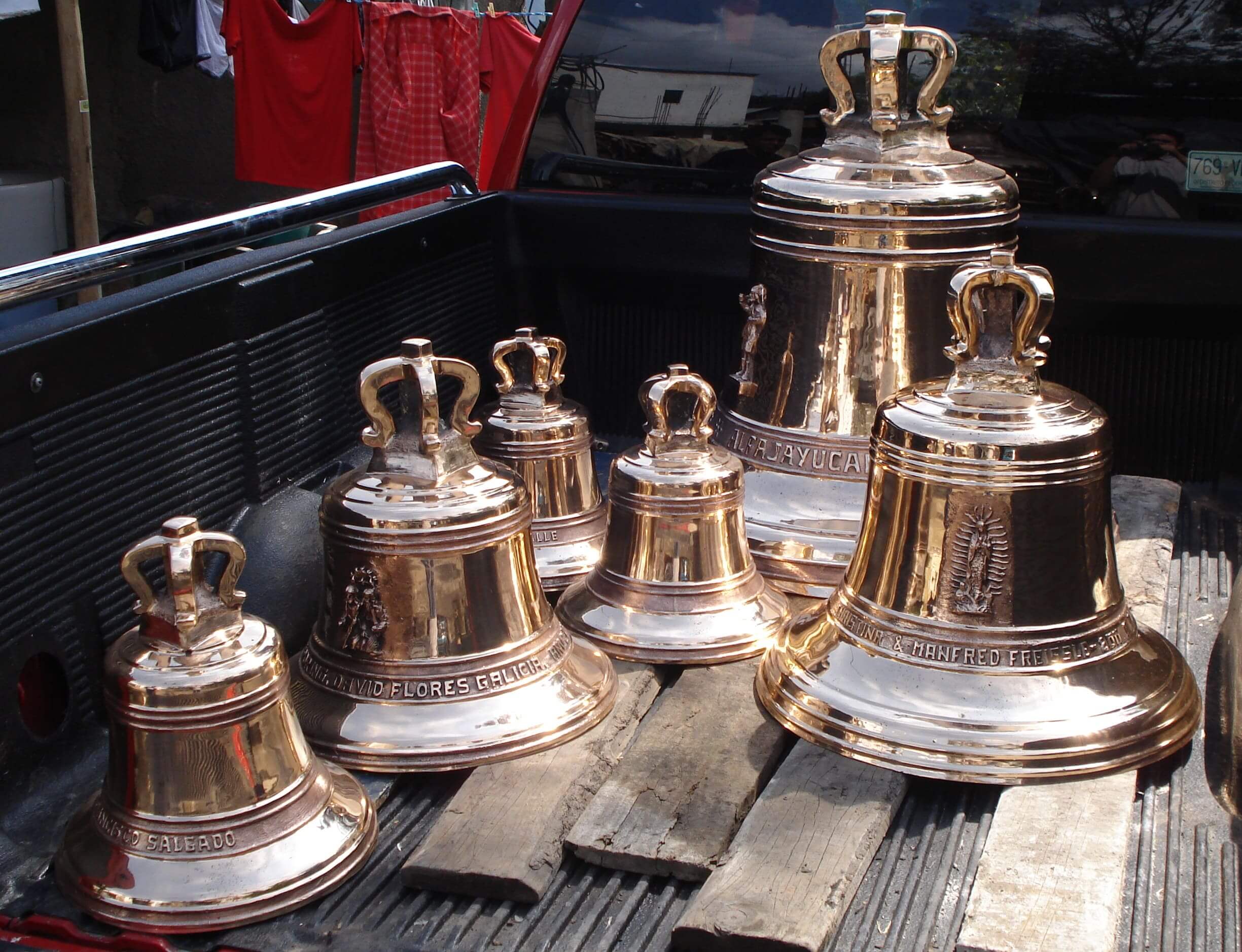 Varias campanas de bronce pulido en la parte trasera de una camioneta.