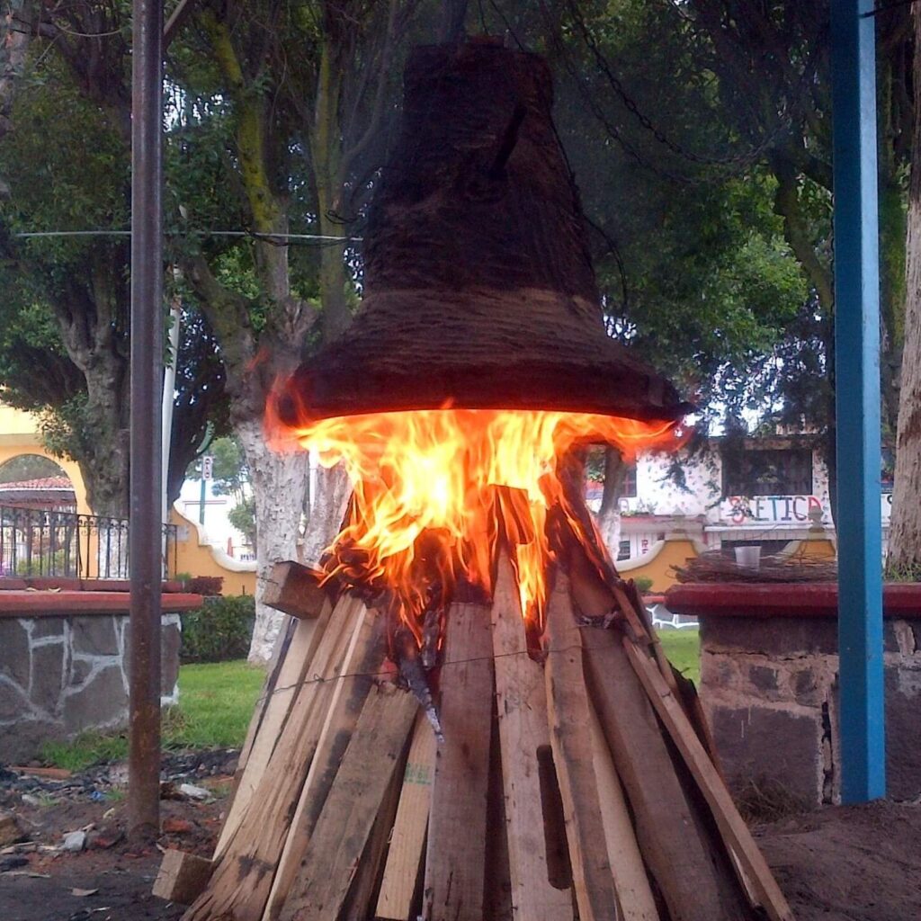 Proceso de refundición de una campana de bronce con fuego en un molde.